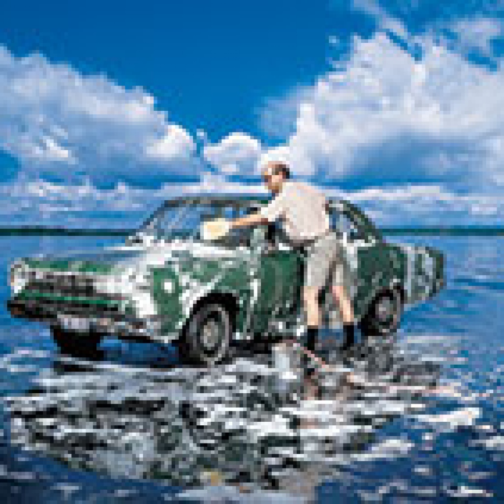 man washing green car in blue ocean